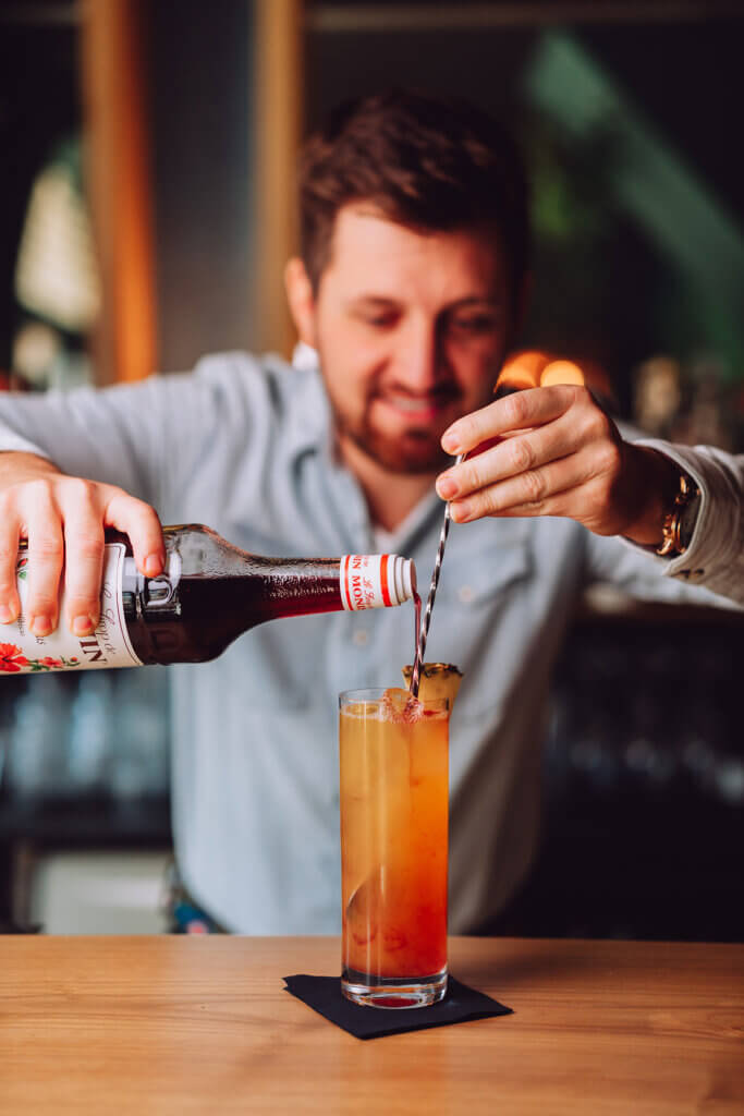 Ein Mann fügt Alkohol in seinen Drink hinzu