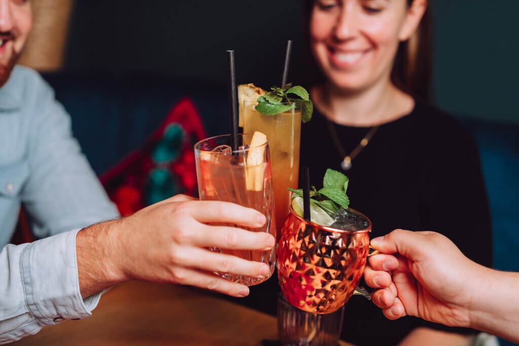 Drei Leute stoßen mit ihren Drinks an